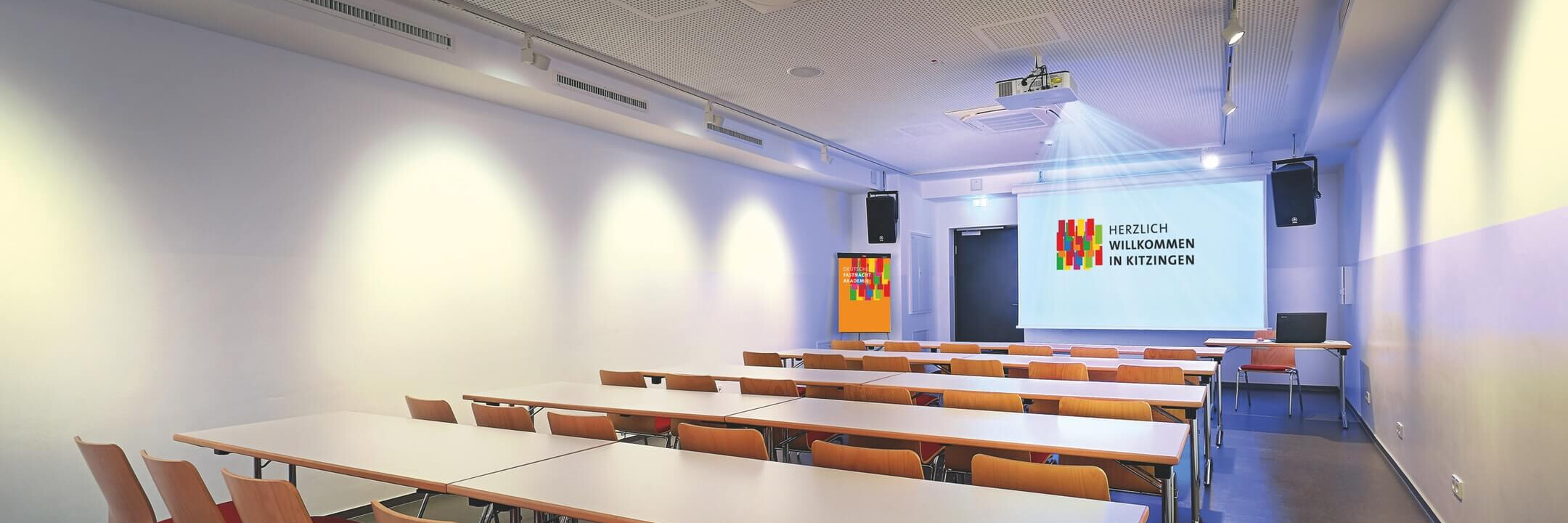 Moderne Konferenzräume in Kitzingen mit Tischen und Projektor | © Name