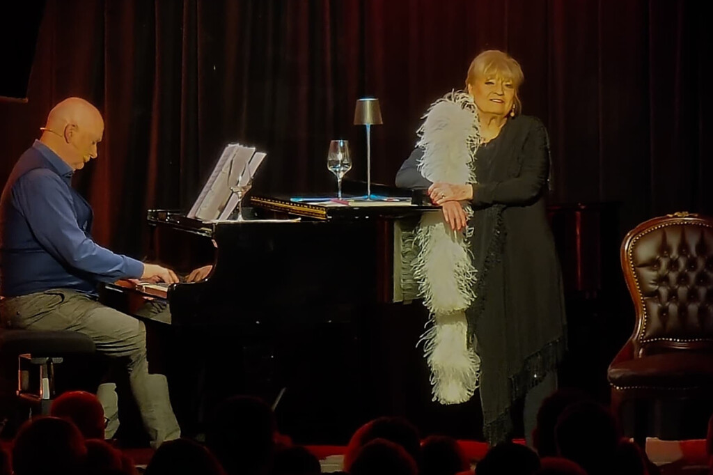 Margit Frank singt am Klavier bei einem Dinner-Event auf der Bühne.