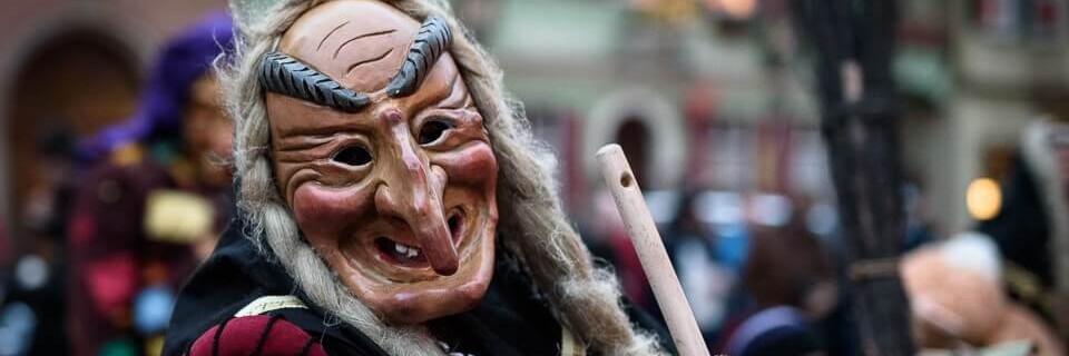 Eine Hexe mit Maske und Besen beim Narrenzunft-Umzug in Dinkelsbühl | © Name