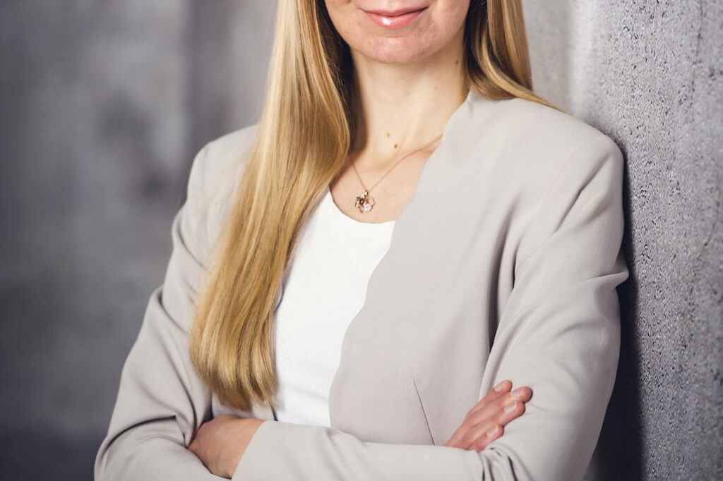Carolin Christoph lächelt selbstbewusst vor einer grauen Wand. | © Florian Steiniger