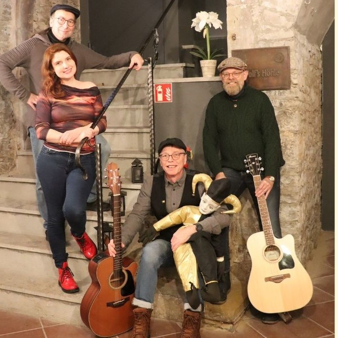 Vier Musiker posieren mit Gitarren in einer gemütlichen Location. | © Name